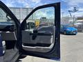 A 2015 Ford F-150 truck with an open driver-side door showcasing the interior design and controls of the vehicle
