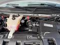A 2020 Chevrolet Express engine compartment with visible components including the coolant reservoir engine cover and various hoses and wires