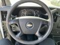 Steering wheel of a 2014 Chevrolet Express with dashboard gauges and controls visible