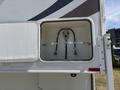 A compartment from a 2018 Westland Travelaire showing a gas connection with two green hoses attached to a metal frame