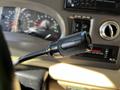 Close-up of the gear shift lever labeled Overdrive in a 2000 Ford Motorhome with dashboard gauges in the background