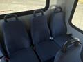 Interior seating of a 2017 Chevrolet Express showing three rows of blue upholstered seats with seatbelts