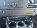 Dashboard of a 2013 Chevrolet Express showing a radio control panel and a console with three cup holders