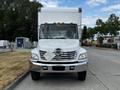 A 2006 Hino 268 box truck facing forward with its distinctive chrome grille and headlight design prominently displayed