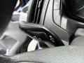 Close-up of the turn signal lever in a 2017 Ford Transit 350 featuring arrow icons for left and right turns along with a headlight control symbol