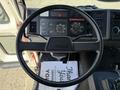 The interior of a 1994 Volvo FE 42 featuring a black steering wheel with the Volvo logo and a dashboard displaying various gauges and controls