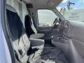 A 2008 Ford Econoline with two front seats covered in black fabric and a center console with cup holders