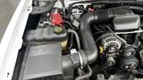 Engine compartment of a 2013 Chevrolet Silverado 1500 showcasing the air intake system battery and coolant reservoir