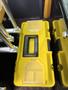 A yellow tool box labeled TOOLS BOX resting on a surface inside a mini excavator