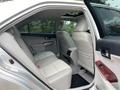 Interior view of a 2012 Toyota Camry showing the rear seats and door panel with light-colored upholstery and wood accents