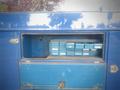 A blue cabinet of a 2012 International DuraStar 4300 with several small storage bins organized inside