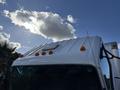 A 2007 GMC W5500 18 foot cube van with a white exterior and orange clearance lights on the roof