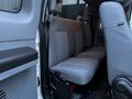 Interior view of a 2015 Ford F-550 showing the rear seat with gray fabric upholstery and seatbelt