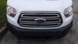 Front view of a white 2018 Ford Transit featuring a chrome grille with the Ford logo and headlights