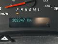 The dashboard display of a 2013 Chevrolet Express showing the odometer reading 302347 km and a temperature gauge