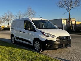 A white 2022 Ford Transit Connect van is parked with a sleek design featuring sliding side doors and distinctive front grille showcasing the Ford logo