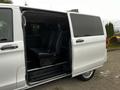 A 2018 Mercedes-Benz Metris with the side door open revealing black seats inside the van