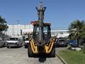 A 2013 John Deere 710K backhoe loader facing forward with prominent front bucket and hydraulic arms extended