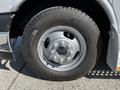A close-up view of a silver wheel with a textured tire mounted on a 2019 Chevrolet Express van