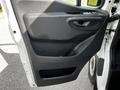 Black interior door panel of a 2020 Mercedes-Benz Sprinter featuring a door handle and armrest design