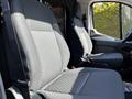 Interior view of a 2023 Ford Transit showing two front seats with black fabric upholstery and a divider between them