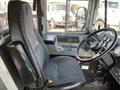 Interior view of a blue bus driver seat with a steering wheel and dashboard controls visible