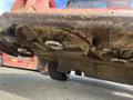 View of the underside of a 2014 Toro Groundmaster 5910 showing the mower blades covered in grass clippings and the wheels on the ground