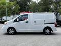 A white 2020 Nissan NV200 van parked with sliding side doors and a compact design suitable for urban driving and commercial use