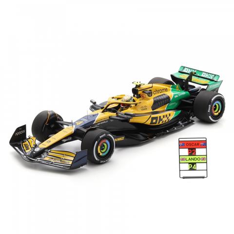 A detailed model car of the Spark McLaren MCL38 representing the 2024 Monaco Grand Prix featuring yellow and green colors and the #4 of driver L. Norris