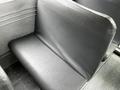 A grey vinyl bus seat from a 2015 Spartan School Bus with a textured surface and minimal padding