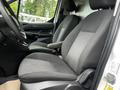 Front seating area of a 2014 Ford Transit Connect featuring gray fabric seats with a simple design and a steering wheel visible on the left