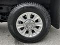 A close-up view of a wheel from a 2020 Ford F-350 SD featuring a silver alloy rim and a large black tire with visible tread patterns