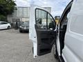 A 2023 Ford Transit van with the driver's side door open showing the interior features and seating arrangement