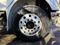 The image shows a close-up of a silver wheel rim with lug nuts and a black tire labeled Goodyear on a 2011 Freightliner M2 106