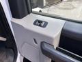 Close-up of the interior door handle and control panel of a 2016 Ford F-150 showing the textured surface and button layout