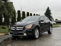 A 2016 Mercedes-Benz GLA-250 in glossy black with sleek lines and distinctive grille emblem parked on a wet surface