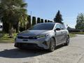 A gray 2024 Kia Forte5 with a sporty design and red accents parked in a sunny area