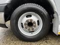 A close-up of a wheel and tire from a 2015 Chevrolet Express showing a silver rim and a Michelin tire with visible wear and rust on the lug nut area