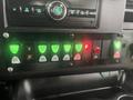 Dashboard controls of a 2017 Chevrolet Express featuring various green and red buttons for lights and functions