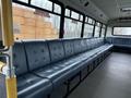 2011 Ford F-550 in a bus interior with blue upholstered seating and safety features visible along the sides