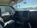 Interior view of a 2013 Chevrolet Express showing the front dashboard and driver’s seat with control panels and cup holders