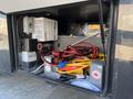 A storage compartment of a 2008 Newmar Canyon Star motorhome filled with various cables and an inverter unit