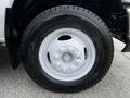 A silver wheel with a Michelin tire mounted on a white vehicle, featuring multiple bolts and a smooth surface