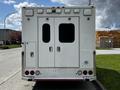 A white 2013 Chevrolet Express with multiple external lights and a double rear door designed for emergency services