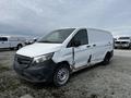 A 2018 Mercedes-Benz Metris cargo van with a white exterior and visible rust on the side is parked in an open area