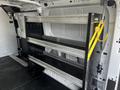 A 2018 Ford Transit interior with a metal shelving unit featuring three levels, designed for storage and organization of tools or equipment