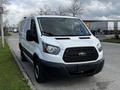 A 2018 Ford Transit van in white with a black grille parked on a street