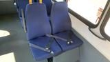 A pair of blue bus seats with seatbelts attached, designed for passenger safety in a 2011 Chevrolet Express