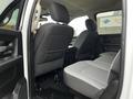 Interior view of the rear seating area of a 2022 RAM 1500 Classic with gray fabric upholstery and a spacious layout