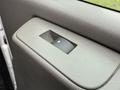 Close-up of the interior door handle of a 2014 GMC Savana showing textured gray plastic with a circular knob for opening the door